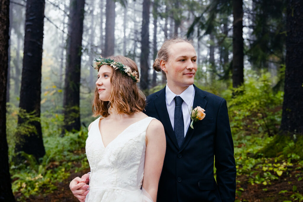 bride and groom in a forest, holding hands